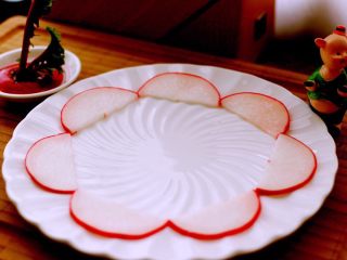 酸甜萝卜花（王氏私房菜）,取一个圆盘子、把最大的片、放到第一层、依次排列整齐、如图