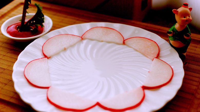 酸甜萝卜花（王氏私房菜）,取一个圆盘子、把最大的片、放到第一层、依次排列整齐、如图