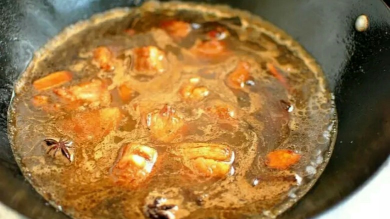 排骨闷饭,加入酱油和老抽继续翻炒让排骨上色，加水没过排骨，再调入料酒和盐调味。