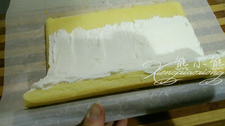 虎皮蛋糕卷--其实很简单,26.用擀面杖，款住蛋糕片一边的油纸，提起来，边用擀面杖卷油纸，边把蛋糕片提起来向下卷。