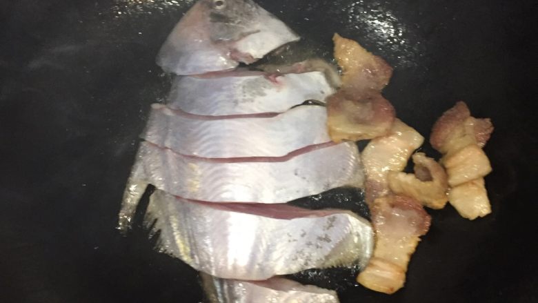 家烧鲳鱼,把五花肉弄至一边，下鲳鱼稍微煎一下，不需要翻面