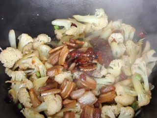 干锅花菜,花菜炒至微软后放入五花肉、老抽、生抽和豆瓣酱翻炒