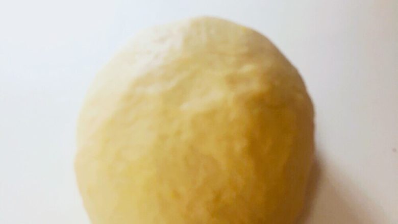 日式南瓜造型面包,材料搅拌均匀成团后放在桌上揉面。
将面揉至出筋，表面光滑的状态，揉面完成。
将面团团成团后，缝口朝下放入面包盆内，盖上保鲜膜。40℃发酵25-35分钟														
														