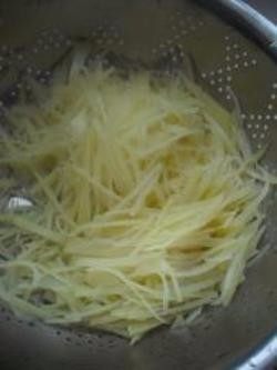 酸辣土豆丝,2.将切好的丝在水龙头下冲洗片刻，冲掉淀粉。
