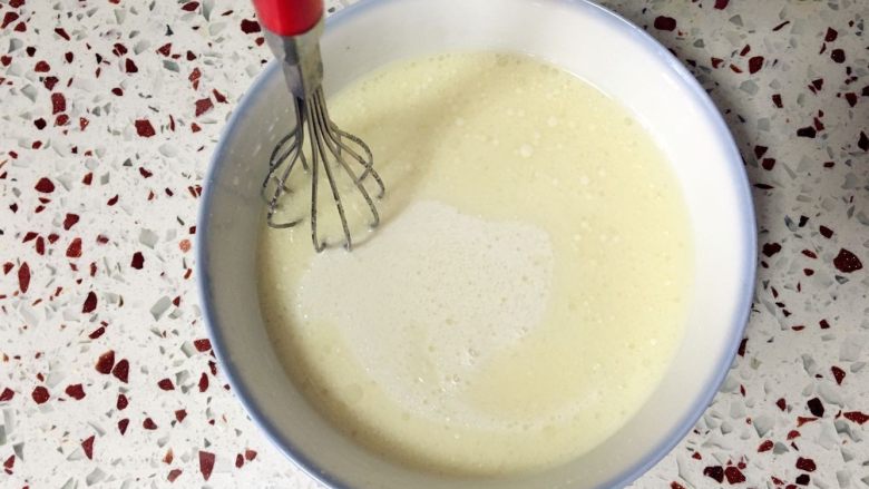 奶黄冰皮月饼,搅拌均匀，用手动打蛋器在上层来回划圈，让油与牛奶糊充分融合。