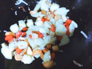 土豆香肠焖饭,倒入土豆翻炒至表面微微焦黄
