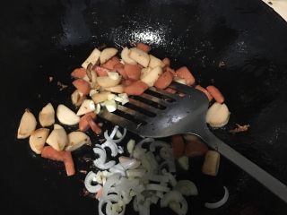 土豆香肠焖饭,翻炒出香味后倒入葱花蒜碎翻炒，倒少许十三香粉