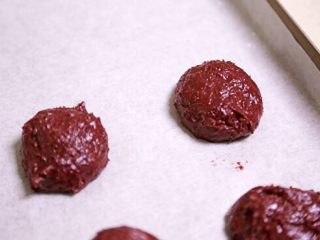 红丝绒曲奇,放冰箱冷藏3小时后取出，用手揉成8个小球，摆在铺了烤纸的烤盘上（间距要大）。