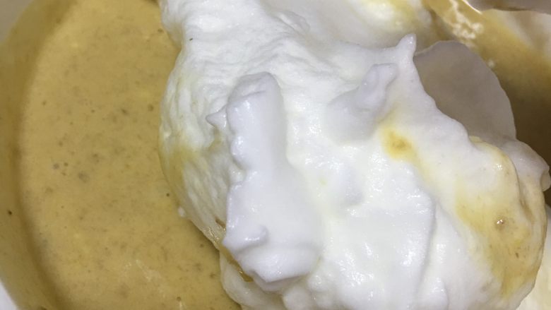 香蕉戚风蛋糕,拿三分之一的蛋白放入面糊中拌匀。