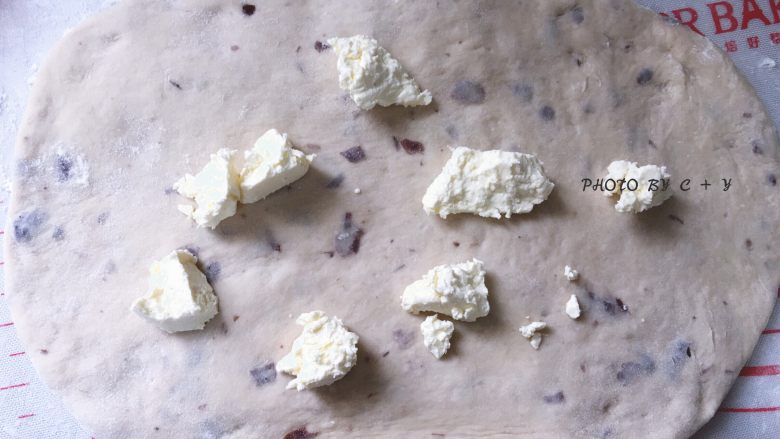 蔓越莓乳酪软欧包,均匀撒上若干小粒状的奶油乳酪。