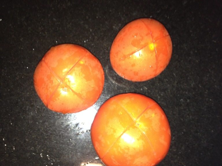 番茄炒年糕,如图把番茄切十字以便在沸水下去皮