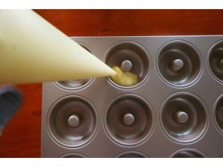 椰香甜甜圈（烤箱版）,甜甜圈面糊装进模具里，如果模具不是不粘模具就在模具壁上轻轻扫一层融化好的黄油。