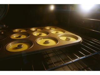 椰香甜甜圈（烤箱版）,放进预热好的烤箱里，上下火160度烤30~35分钟。