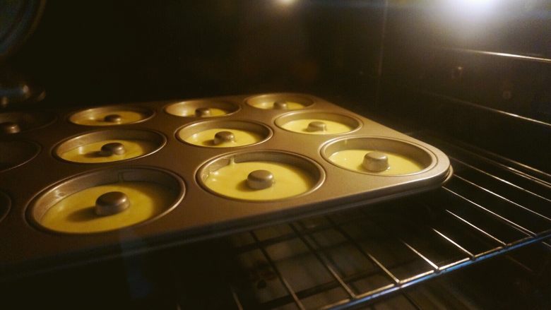 椰香甜甜圈（烤箱版）,放进预热好的烤箱里，上下火160度烤30~35分钟。