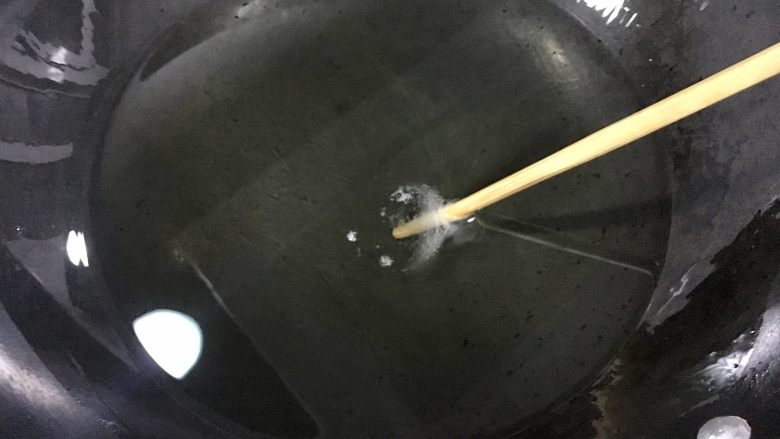鸡米花,锅里倒入适量的油，烧到七八成热，也就是把一根竹筷子放进去后有泡泡出来，如图的样子就行，就可以把肉块下锅了