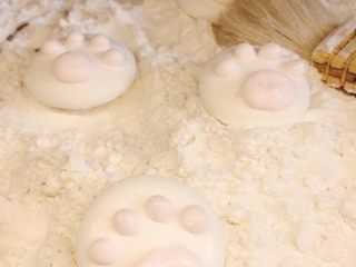 超萌的猫爪棉花糖,在白色猫爪上，用粉色糖糊挤四个小点，一个大点做猫的肉脚垫。放冰箱冷藏1小时，或者室内放半天，然后用毛刷刷去爪子上多余的粉，就大功告成啦。