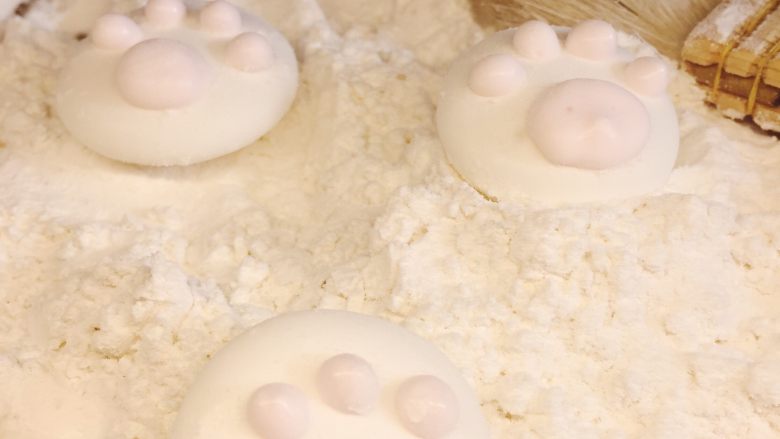 超萌的猫爪棉花糖,在白色猫爪上，用粉色糖糊挤四个小点，一个大点做猫的肉脚垫。放冰箱冷藏1小时，或者室内放半天，然后用毛刷刷去爪子上多余的粉，就大功告成啦。