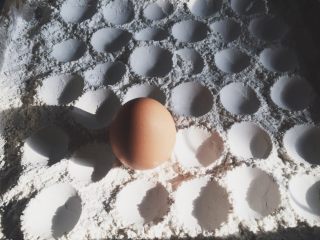 超萌的猫爪棉花糖,提起用鸡蛋大的一头在熟粉上戳个坑。注意鸡蛋要洗干净。熟粉可以用无水无油的不粘锅，小火炒熟。判断熟的办法，一是放嘴里尝一下，无生粉味道；二是观察炒熟的玉米淀粉想对松散，表面微黄。炒的时候一定勤翻，一定不要糊。玉米淀粉的味道会影响棉花糖的味道的。