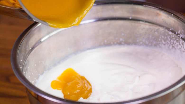 【免烤箱蛋糕】零失败芒果慕斯蛋糕,将淡奶油和芒果溶液混合，用刮刀翻拌均匀。即成芒果慕斯液。