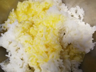 酱油炒饭,把打散的鸡蛋液倒入米饭里，用手拌匀并捏散米粒。