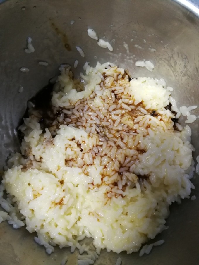 酱油炒饭,接着加入之前调好的酱油料，同样充分拌匀，使米粒上都均匀包裹酱料和蛋液。