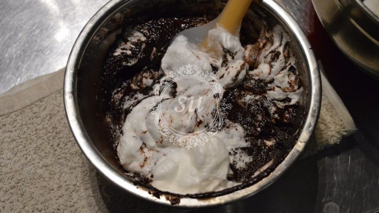 经典巧克力蛋糕,先取1/3的蛋白加入到巧克力糊中，，翻拌均匀。再加入剩余蛋白的1/2继续翻拌均匀。最后将巧克力糊倒入剩余的蛋白中快速翻拌均匀至有光泽且看不到