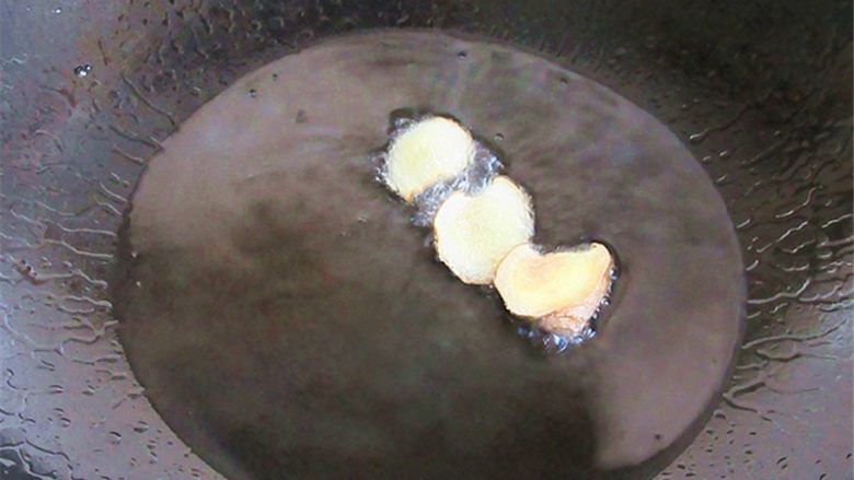 五花肉炒蒜薹,锅内注入油烧制6分热，放入姜片炸制金黄捞出