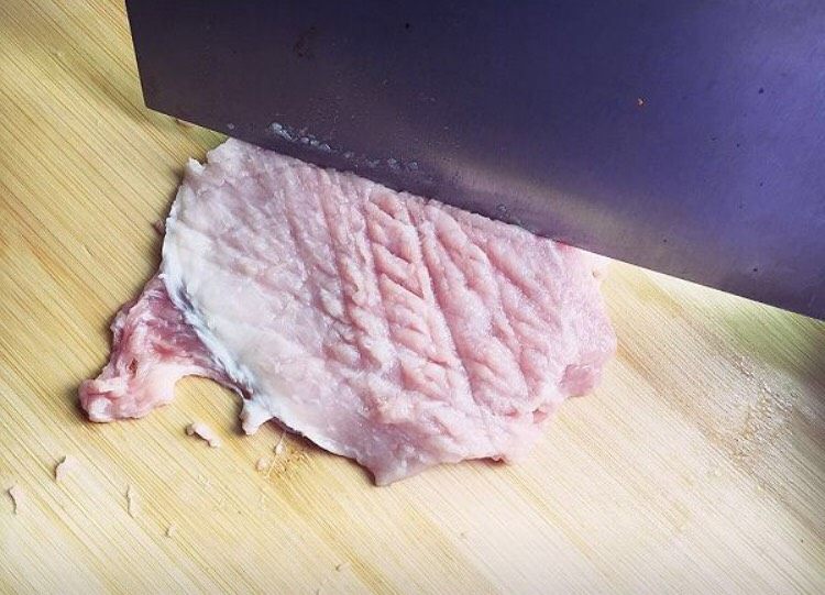 黄金猪排,切半厘米厚的大片，用刀拍松再用刀背轻轻敲开一些。