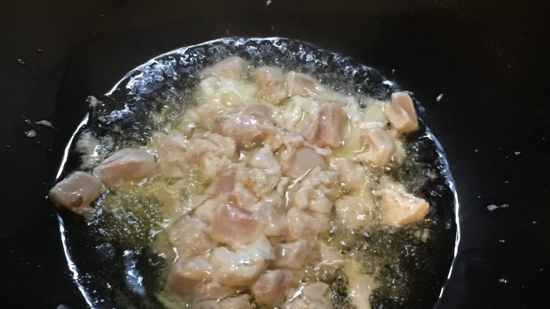 宫保鸡丁盖浇饭,锅中烧热油后滑入腌制好的鸡肉丁，炸制变色后捞出备用