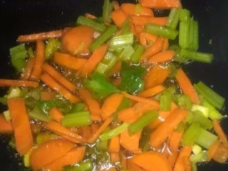 家常炒面,将胡萝卜芹菜放入锅中炒熟。