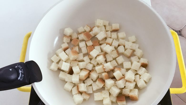 宝宝辅食：吐司爆米花-24M+ ,把吐司切小丁，放入平底锅中小火烘成边缘金黄，取出备用，烘的时候可以用勺子搅拌下，让吐司上下都受热。
》要控制好火候哈，不要烘焦。