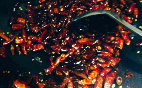 刀口辣椒,待干红辣椒煸至焦褐色，声音清脆作响时盛出，摊开晾凉。