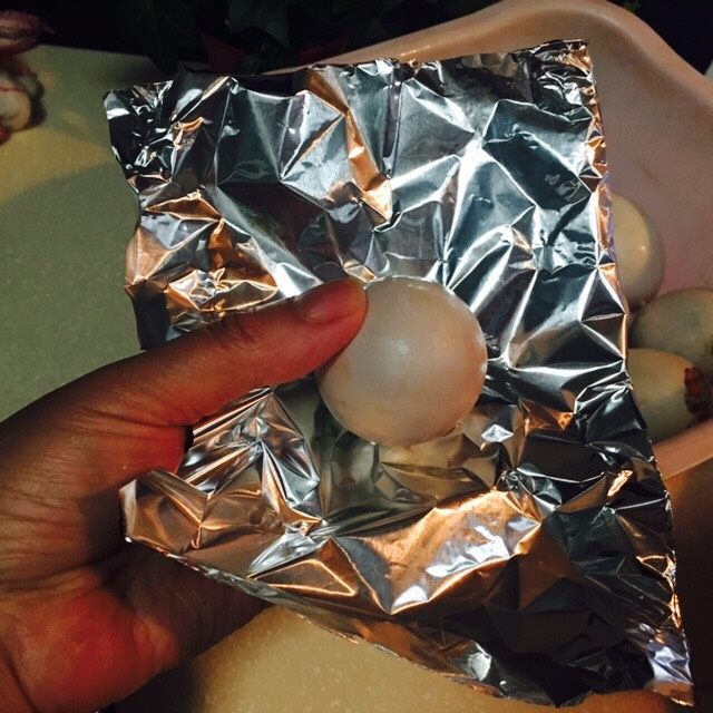 好吃的糯米蛋,把剥掉蛋壳的咸鸭蛋顶部放在锡纸上，随后包起来。防止蒸的时候，水蒸气进入。