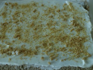 普洱芝麻蛋糕卷,淡奶油打发，抹在蛋糕体上，撒上焦糖芝麻，卷起，冷藏定型。