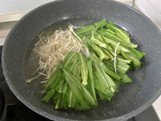 金汤鱼,加入少许食用油，水再开加入绿豆芽油麦菜，焯水半分钟捞出