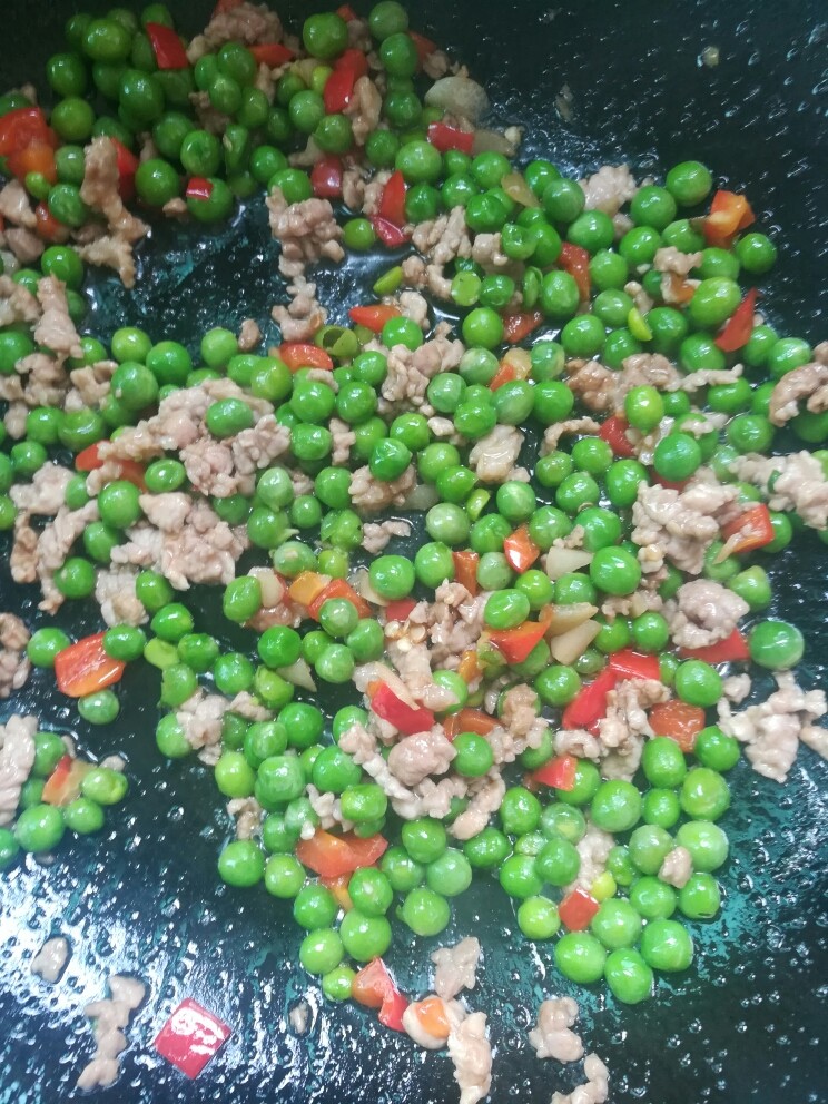 酸菜肉沫炒豌豆,下肉丁炒散，撒适量盐，味道与肉一起炒匀。
