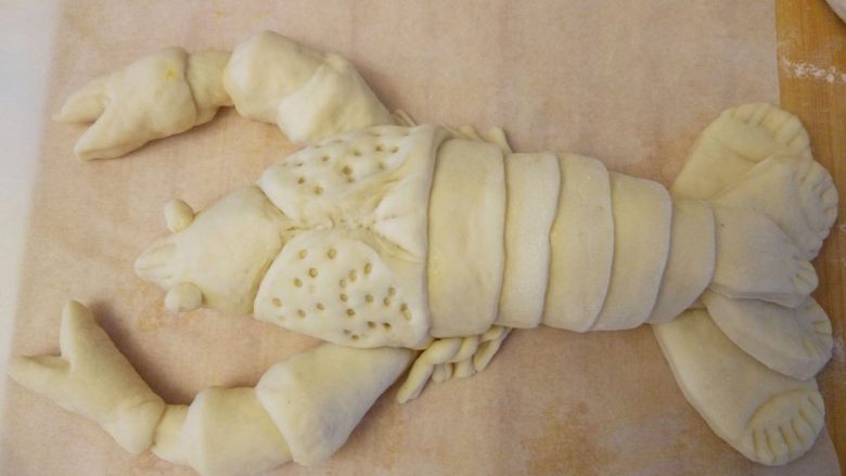 龙虾面包,用牙签扎出头部孔洞的花纹。用牙签稍粗的一端，如果是尖端，发酵后就闭合了