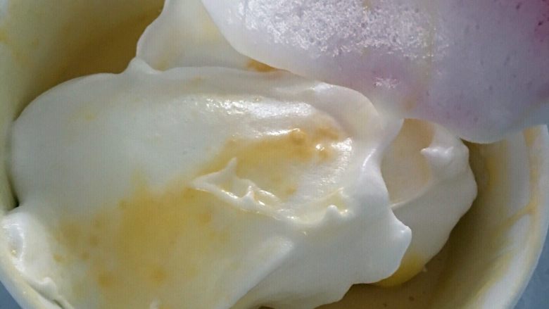 炫彩（三色）戚风蛋糕,三分之一的蛋白倒入蛋黄液中，搅拌均匀。