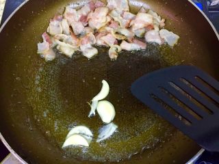 『「奶油培根意面」』,煎好的培根推至锅里的一旁，放入蒜片炒香