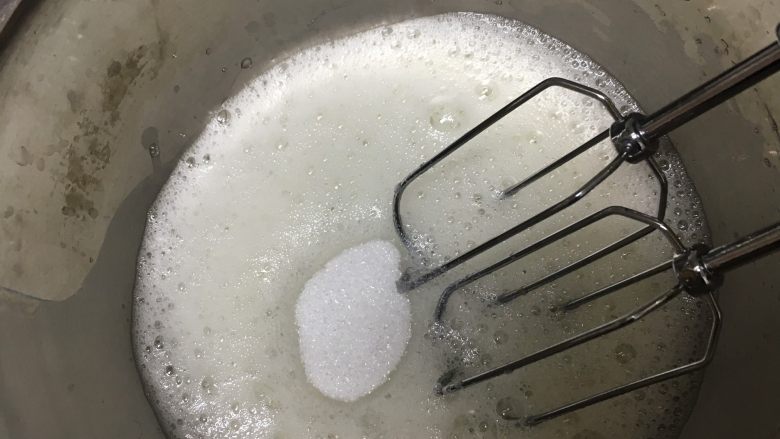 宝宝零食～奶溶豆,蛋清用打蛋器打出泡沫状态，第一次加入砂糖。