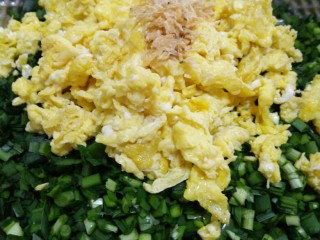 韭菜鸡蛋水饺,将切好的韭菜、虾皮和晾凉的鸡蛋碎放入盆中。