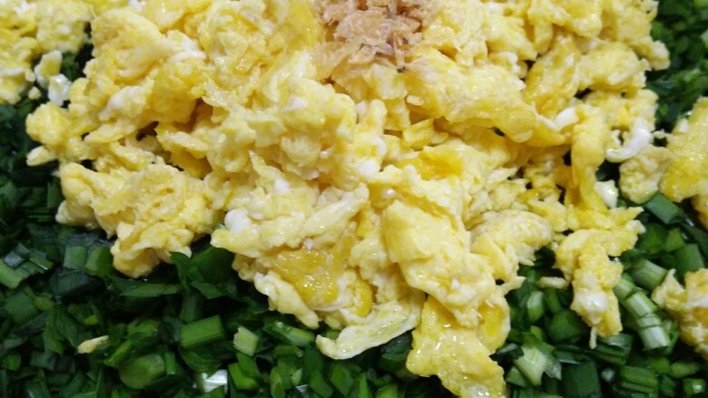 韭菜鸡蛋水饺,将切好的韭菜、虾皮和晾凉的鸡蛋碎放入盆中。