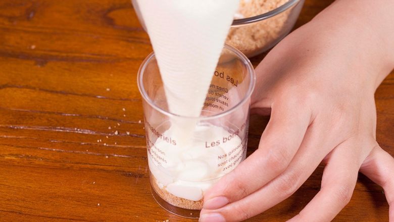 木糠杯,在杯子中加入一层饼干碎，挤一层淡奶油；