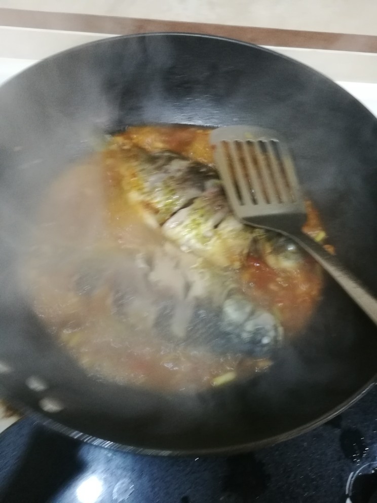 豆瓣鲫鱼,放入鱼烹，适时翻煮。煮的过程中可以将汤汁舀在鱼身上