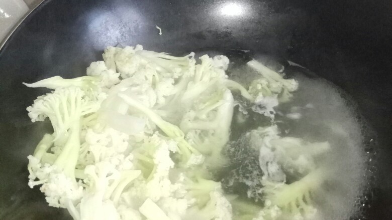 炒白花菜,把锅洗干净将清水放锅里煮沸后，将拔好的白花菜放窝里撩到半分熟，捞起来，放盆子里备用。（可放在第一次步骤，省的洗锅费劲）
