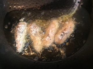 一虾两吃,锅内放油烧热，虾头入锅内炸熟至表面金黄捞出沥干。