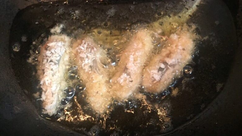 一虾两吃,锅内放油烧热，虾头入锅内炸熟至表面金黄捞出沥干。