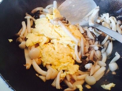菌菇炒蛋,炒的差不多，可以把鸡蛋倒进去。继续翻炒一下。