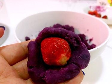 紫薯草莓雪球,把草莓放入，慢慢把周边的紫薯均匀地向内推慢慢收口。