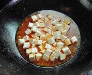 鱼香豆腐,下入所有调料和豆腐轻轻推匀，盖上盖子大火烧开转中火煮至剩余适量汤汁